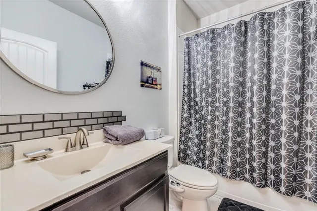 a bathroom with a sink a toilet and a mirror