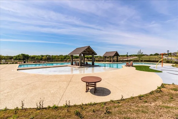 a view of swimming pool with outdoor seating and yard in the back
