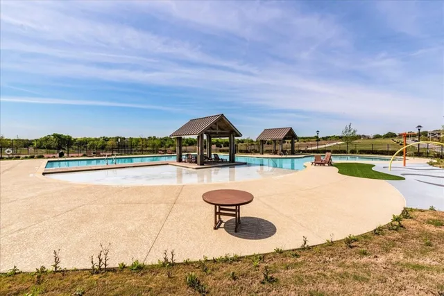 a view of swimming pool with outdoor seating and yard in the back
