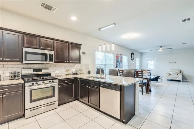 a kitchen with a stove sink microwave and cabinets