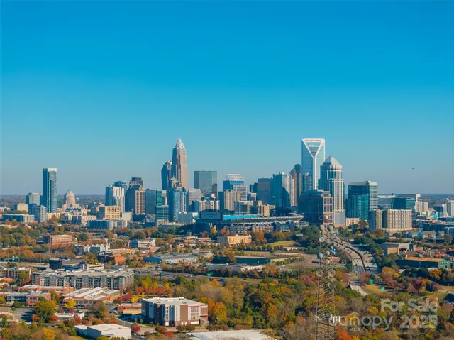 an aerial view of residential houses with outdoor space and trees