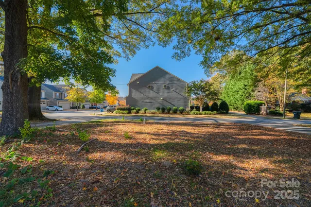 a view of house with yard and trees in the background