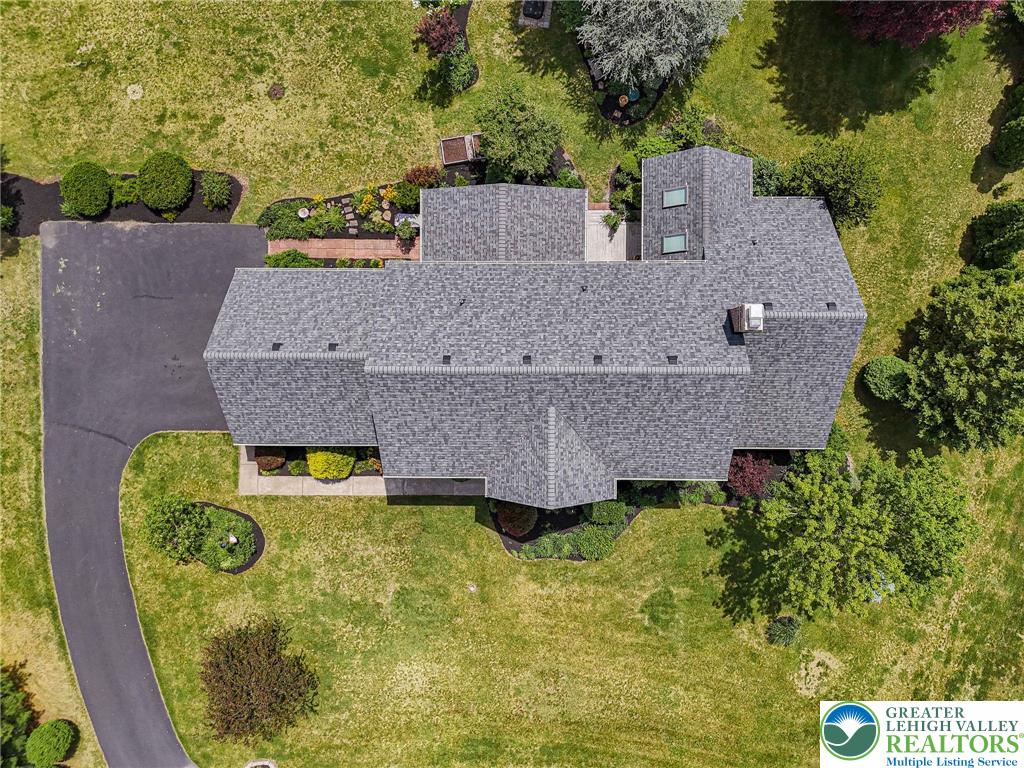 4542 Springfield Drive Coplay, PA 18037 - Photo 77 of 89 An aerial perspective showcases the home's roof, asphalt driveway, and verdant surrounding landscape.