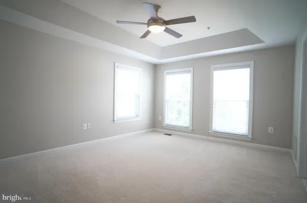 an empty room with a window and a ceiling fan