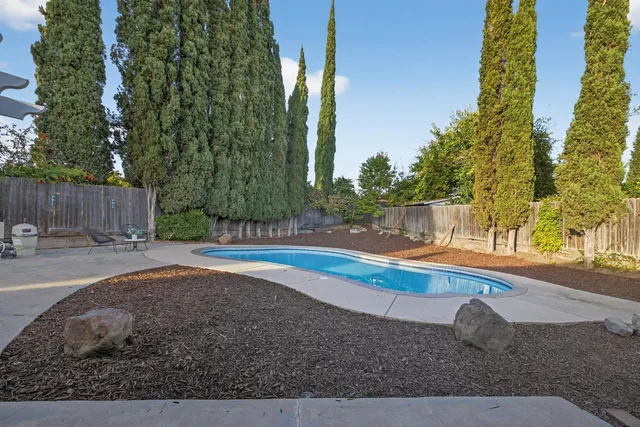 a view of a house with a yard and wooden fence