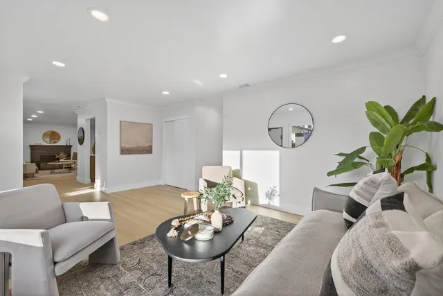 a living room with furniture a mirror and a table