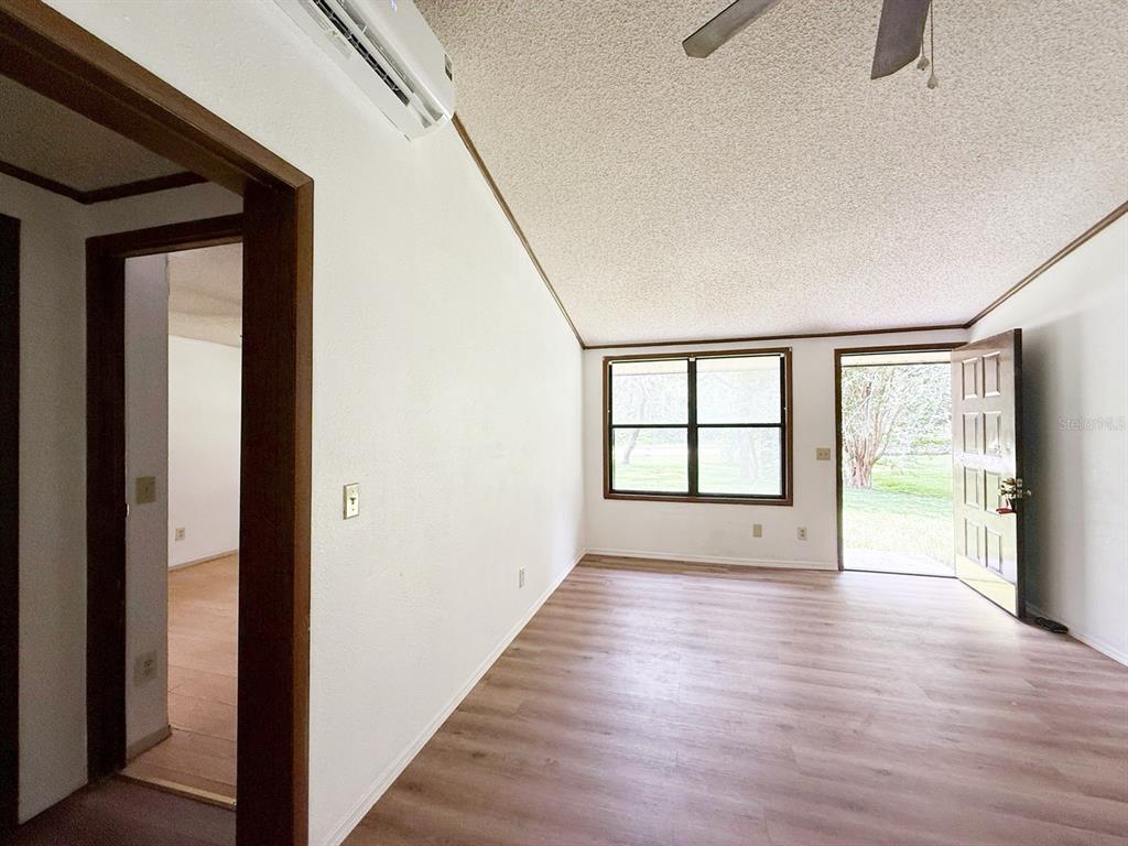 33248 Ridge Manor Boulevard Dade City, FL 33523 - Photo 4 of 20 a view of an empty room with a window and wooden floor