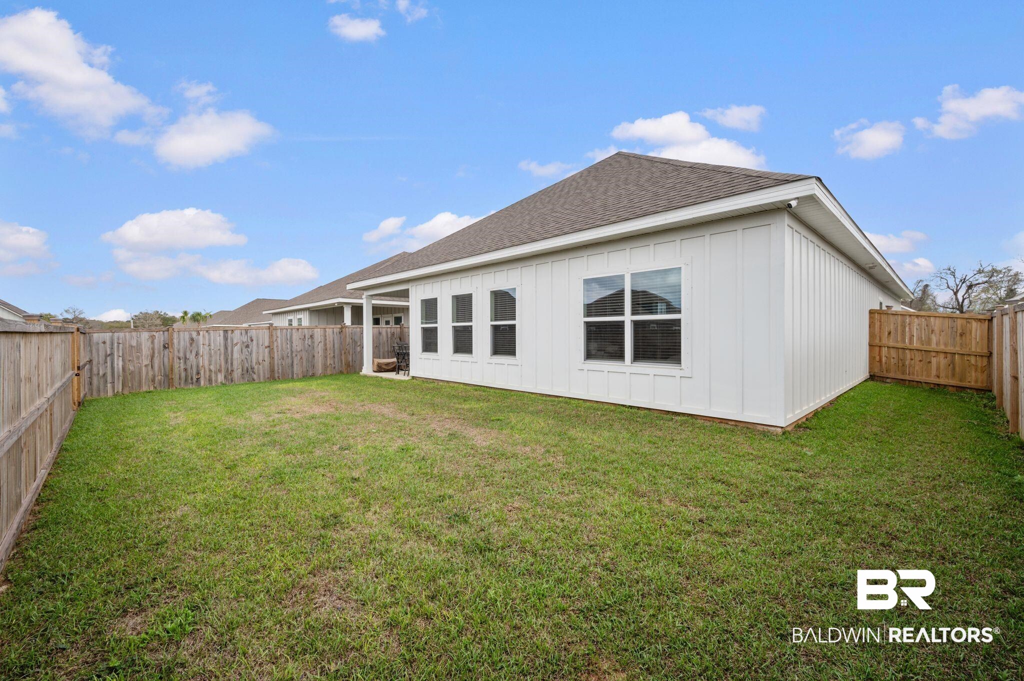 8508 Rosedown Lane Daphne, AL 36526 - Photo 25 of 29 Rear view of house featuring board and batten siding, a shingled roof, and a fenced backyard