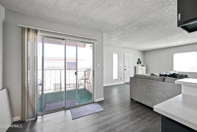 a living room with furniture a flat screen tv and a floor to ceiling window