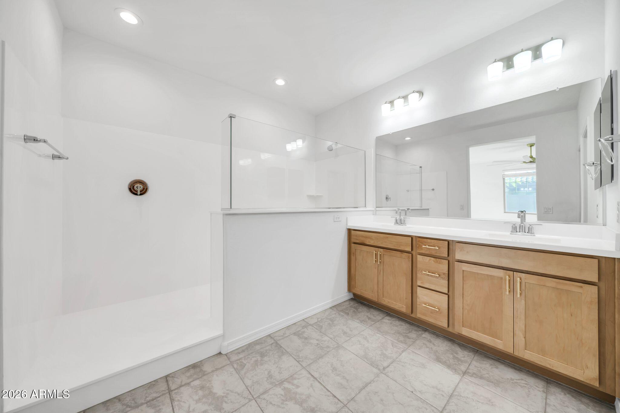 10223 West Piccadilly Road Avondale, AZ 85392 - Photo 10 of 35 a spacious bathroom with a shower a sink and a mirror