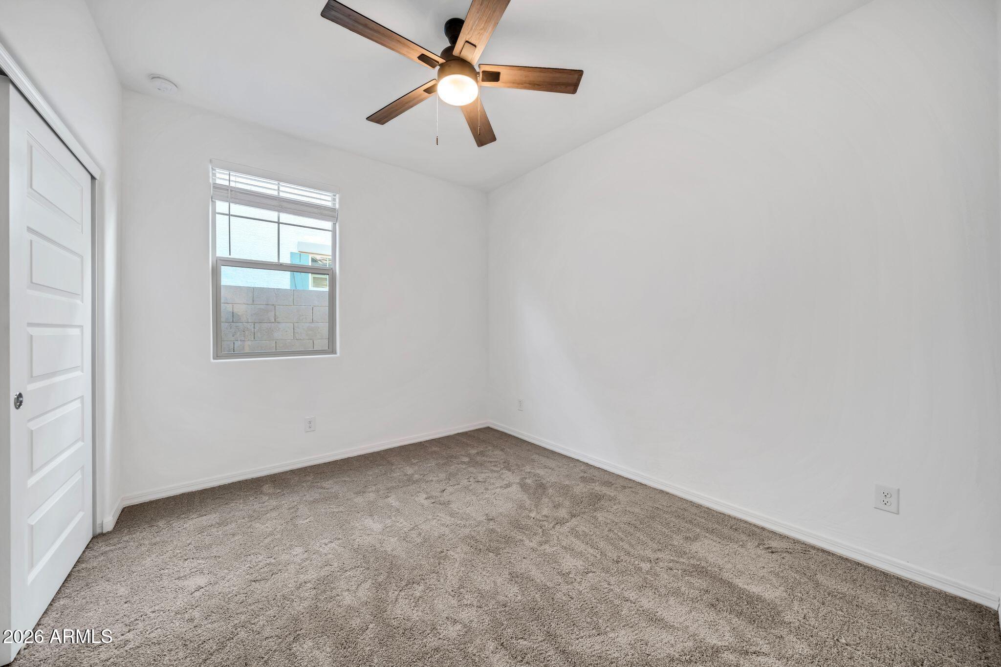 10223 West Piccadilly Road Avondale, AZ 85392 - Photo 11 of 35 an empty room with a window and a fan