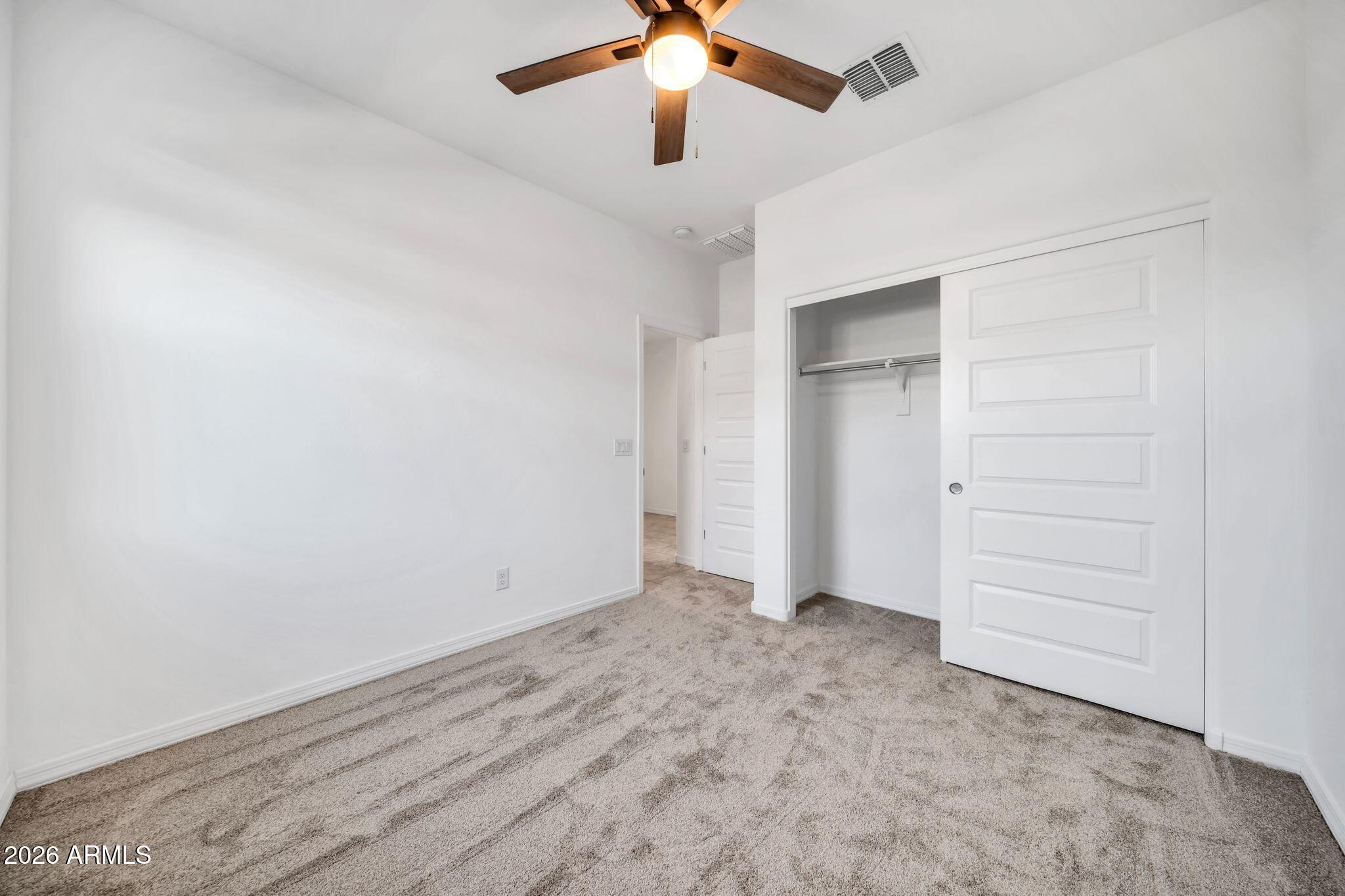 10223 West Piccadilly Road Avondale, AZ 85392 - Photo 14 of 35 an empty room with closet and a ceiling fan