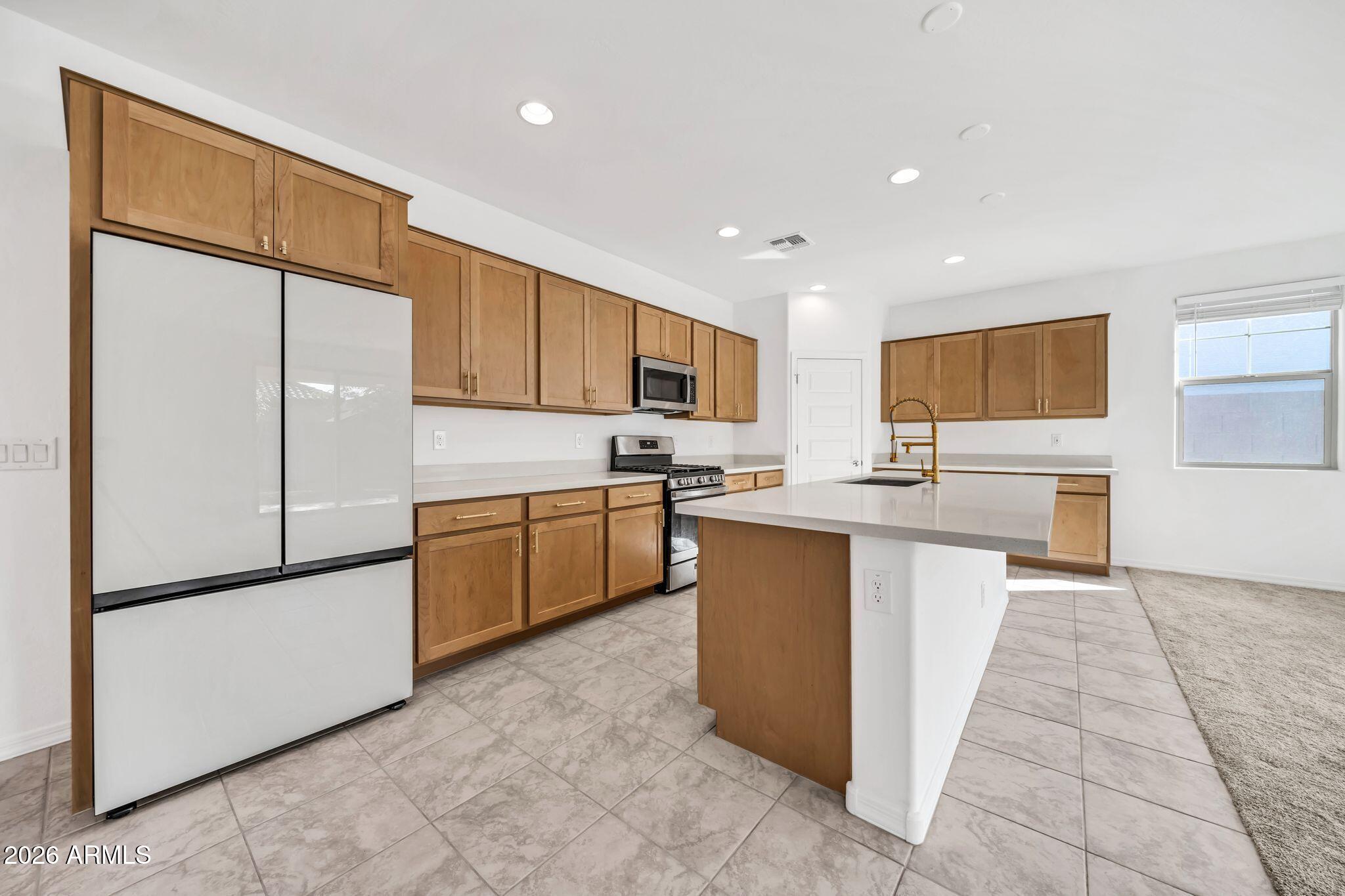 10223 West Piccadilly Road Avondale, AZ 85392 - Photo 2 of 35 a kitchen with granite countertop a refrigerator and a sink