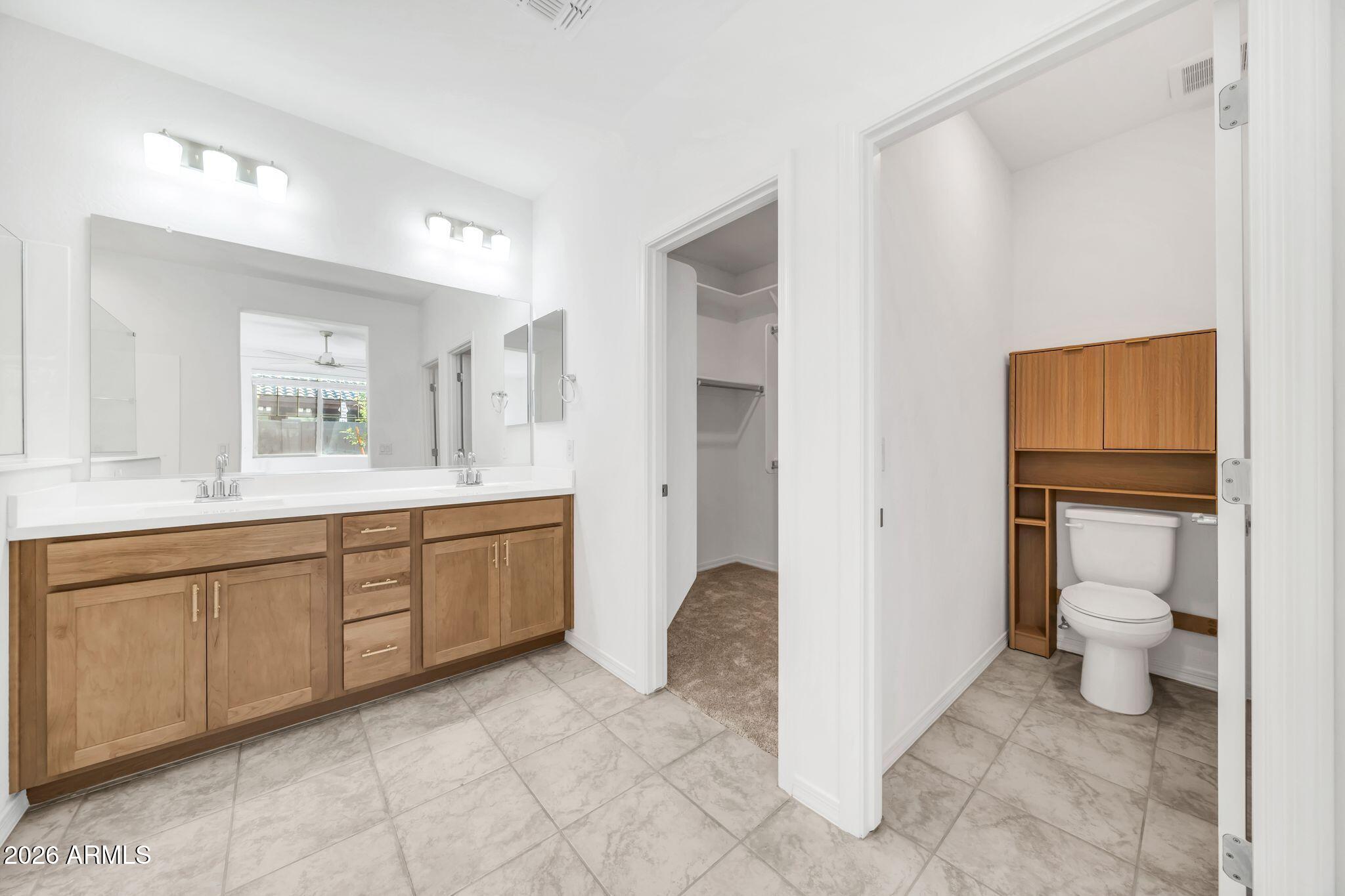10223 West Piccadilly Road Avondale, AZ 85392 - Photo 9 of 35 a spacious bathroom with a granite countertop sink toilet and a mirror