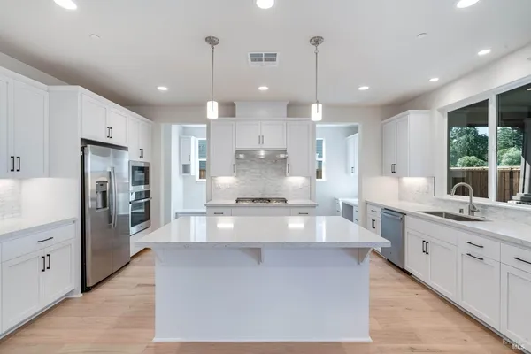a large kitchen with stainless steel appliances kitchen island granite countertop a large counter top a sink stainless steel appliances and cabinets