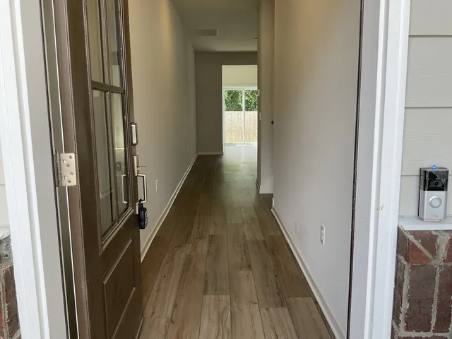 a view of a hallway with wooden floor and staircase