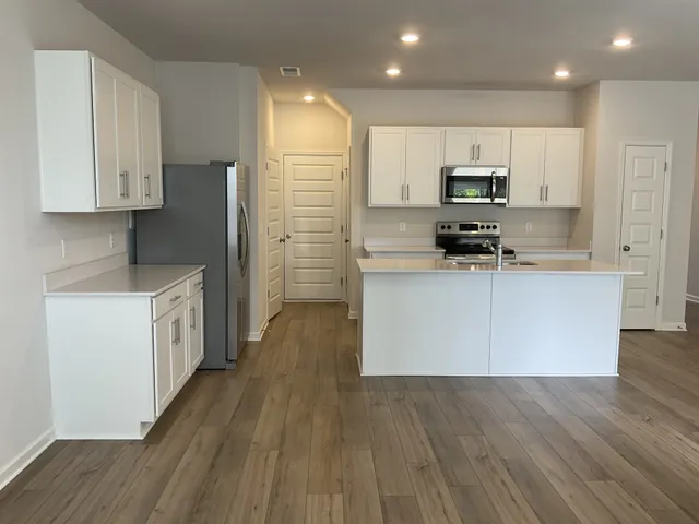 a kitchen with stainless steel appliances a refrigerator sink and microwave