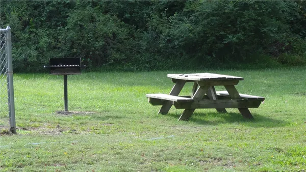 a view of a bench in the garden near a lake