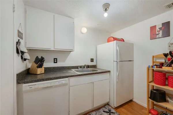 a kitchen with sink refrigerator and cabinets