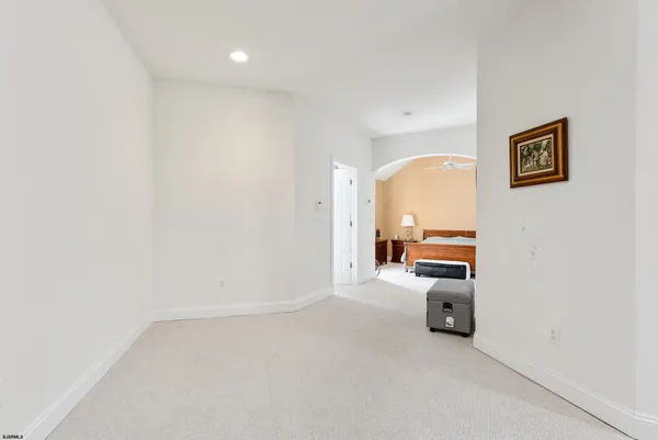 a bedroom with a large bed and a flat tv screen on dresser