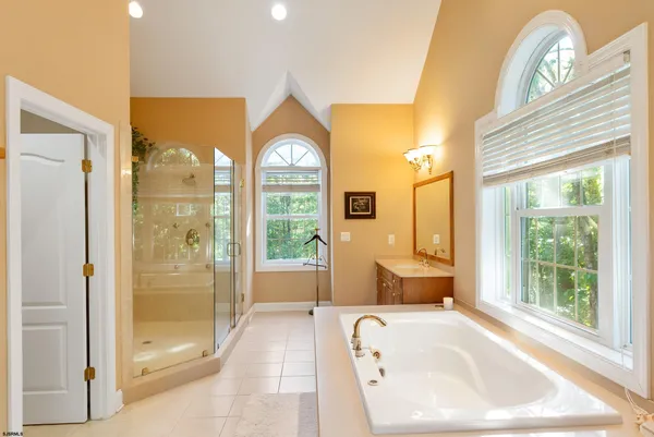 an empty room with windows and chandelier fan