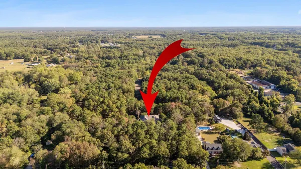 an aerial view of residential houses with outdoor space and trees