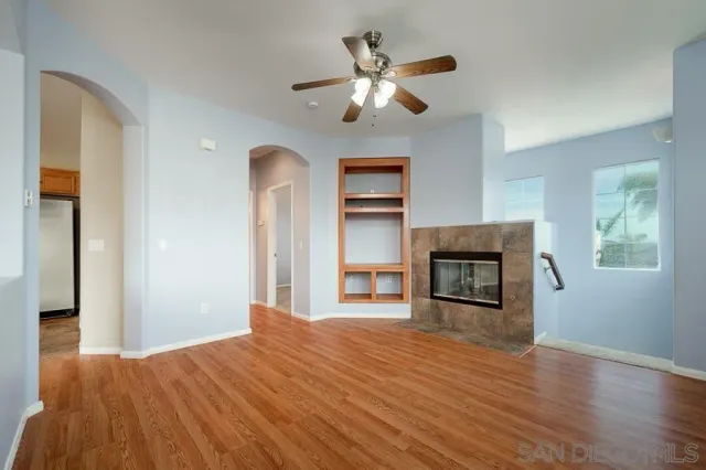 a view of a livingroom with a fireplace a chandelier and wooden floor
