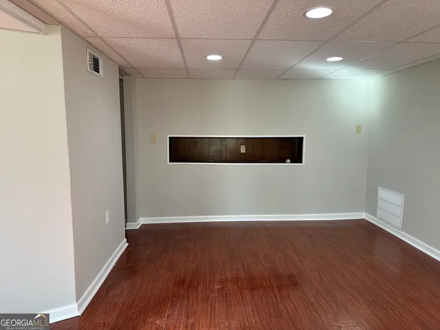 a view of an empty room with wooden floor