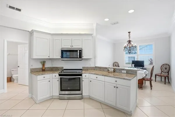 a kitchen with a sink stove and white cabinets