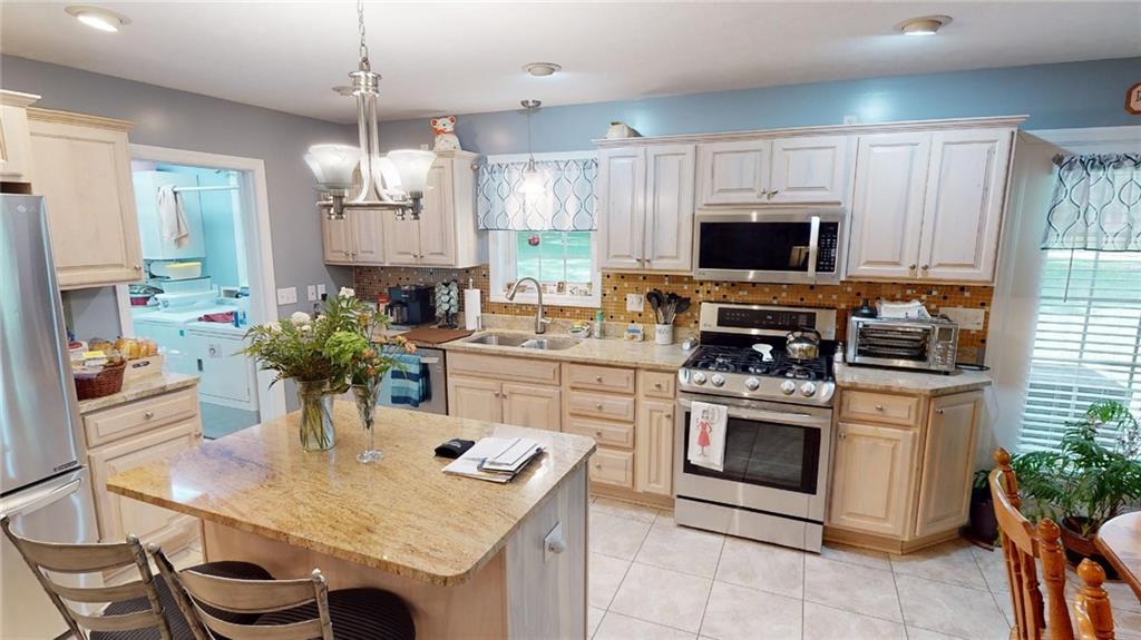123 Hunt Road Butler, PA 16001 - Photo 9 of 44 a kitchen with kitchen island granite countertop a sink stove and microwave