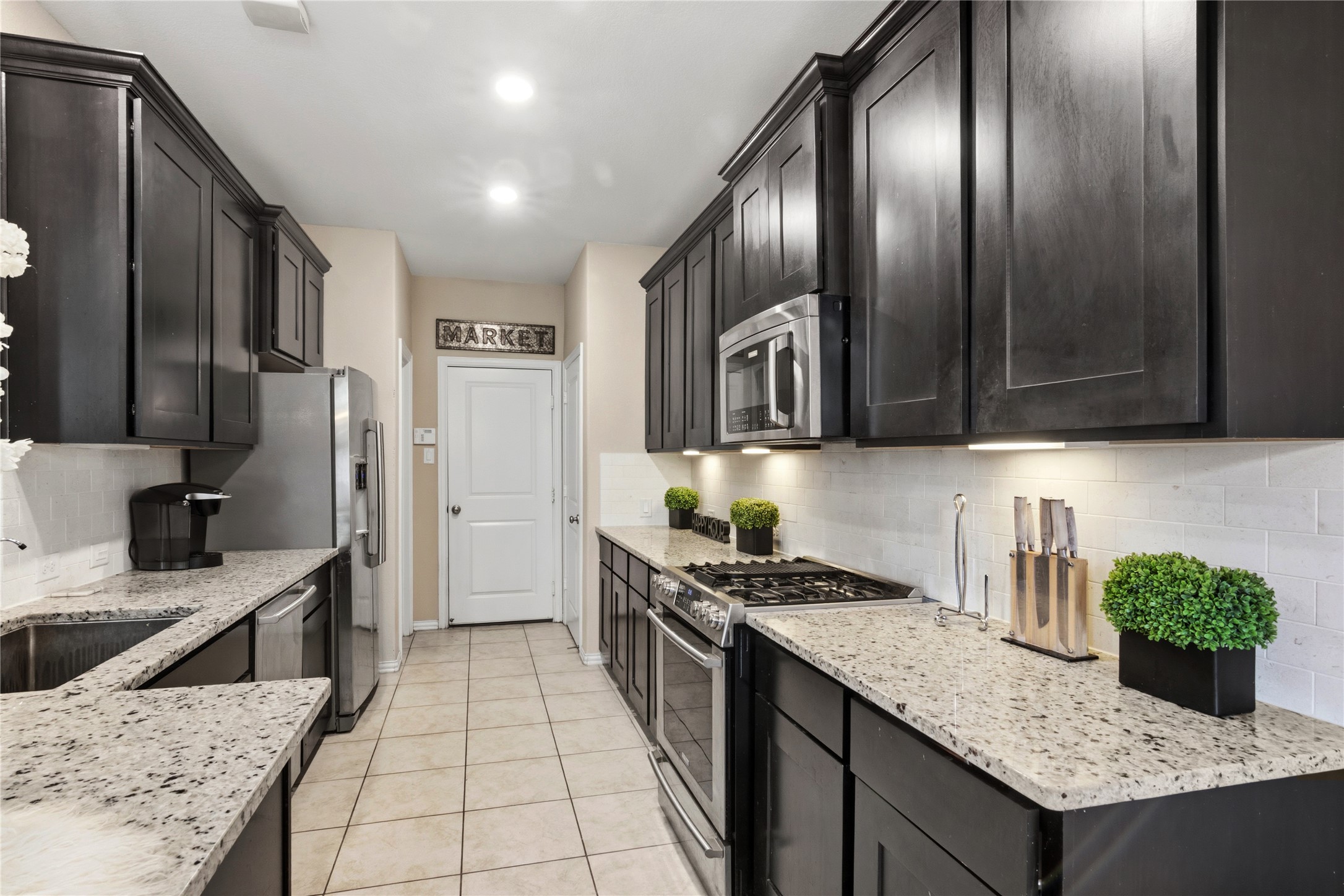 1815 Ryon Falls Drive Richmond, TX 77469 - Photo 9 of 24 a kitchen with stainless steel appliances granite countertop a sink stove and refrigerator