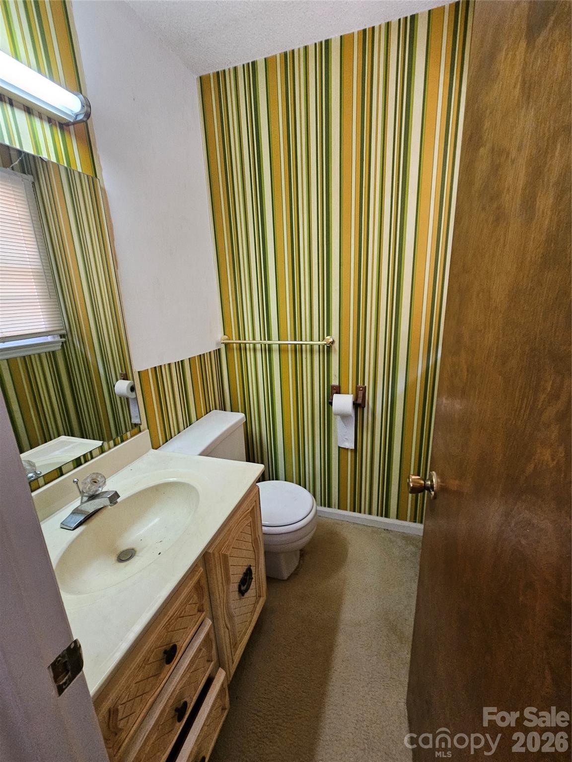 7440 Tuckaseegee Road Kannapolis, NC 28081 - Photo 11 of 17 a bathroom with a sink a mirror and a toilet