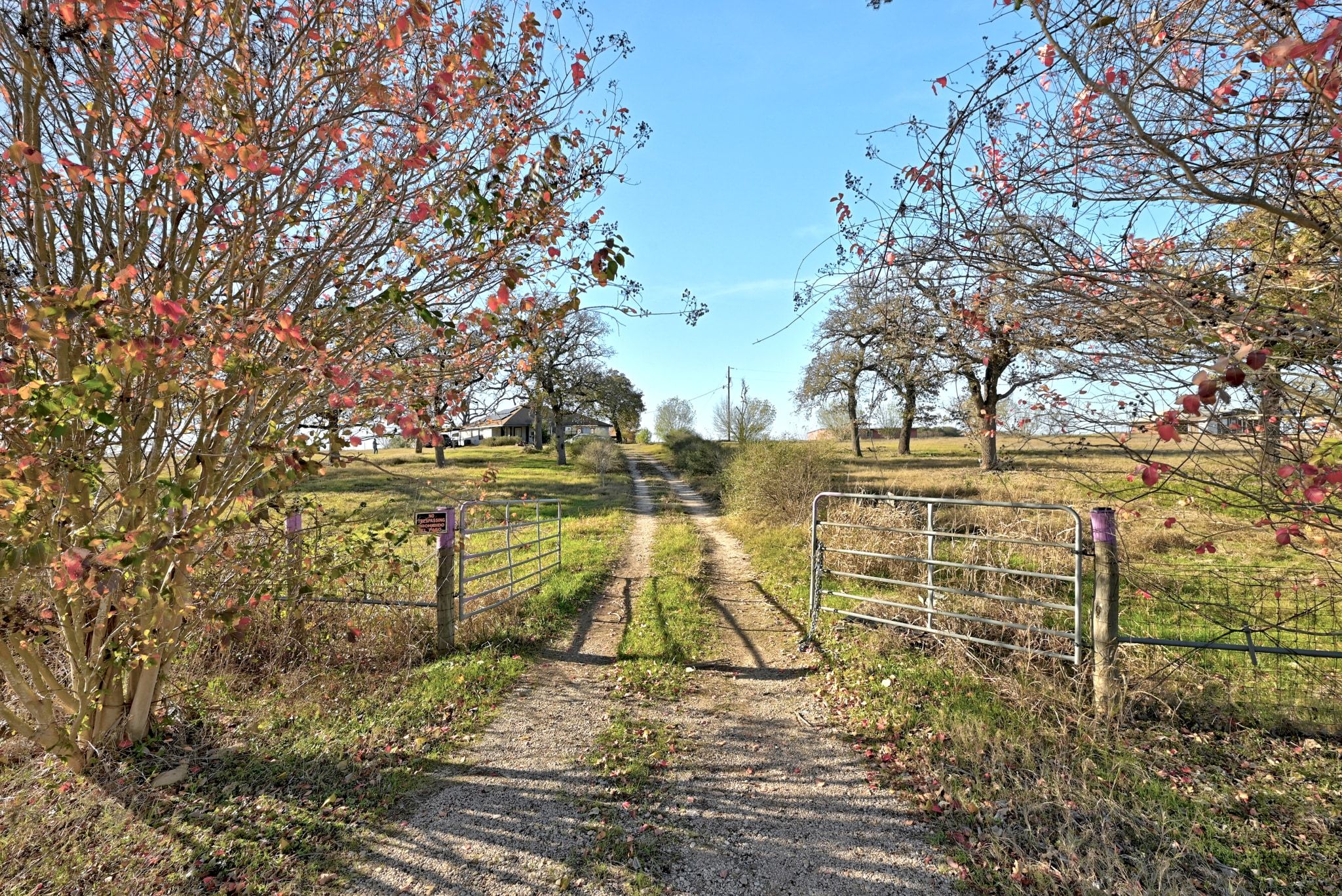 View of dirt / gravel road featuring a gate, a gated entry, and a rural view