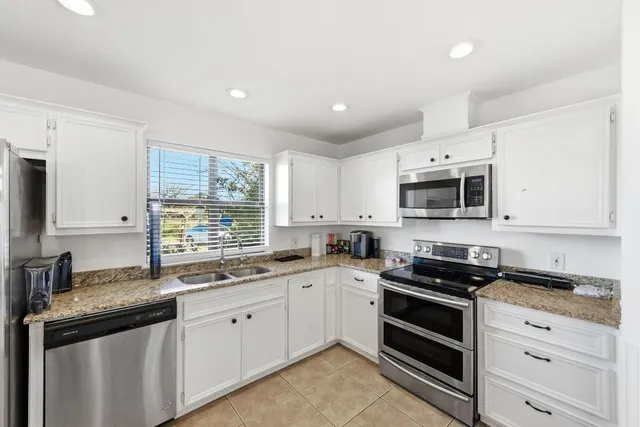 a kitchen with appliances a sink and cabinets