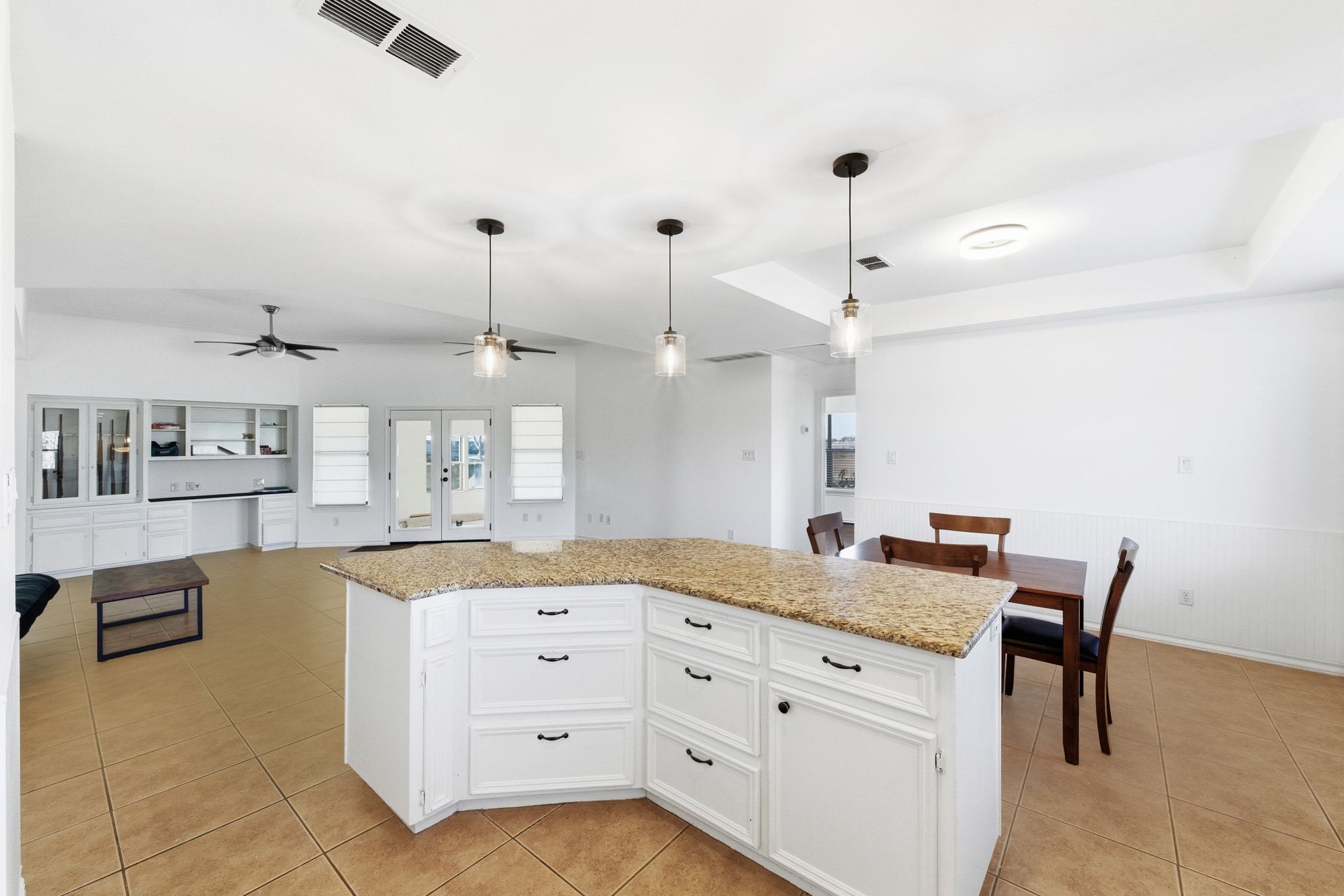 162 Farm To Market 672 Dale, TX 78616 - Photo 12 of 40 Kitchen featuring white cabinets, decorative light fixtures, a kitchen island, light stone counters, and a raised ceiling