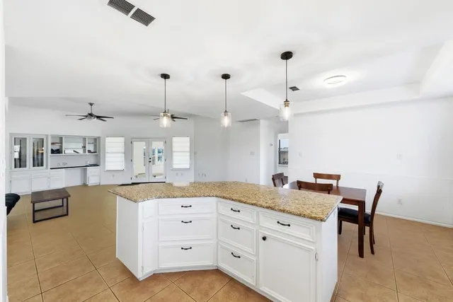a kitchen with granite countertop white cabinets and white appliances
