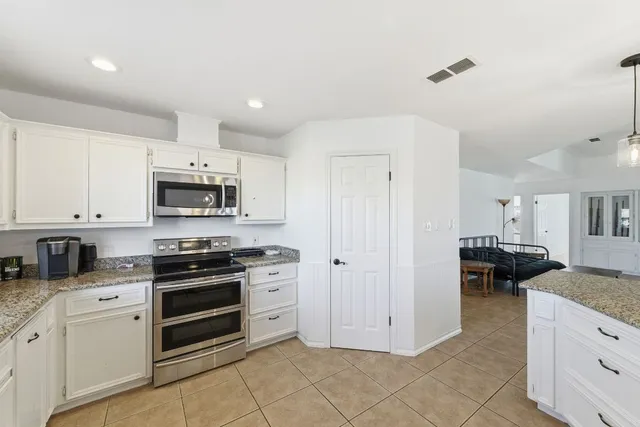 a kitchen with stainless steel appliances granite countertop a stove and a sink