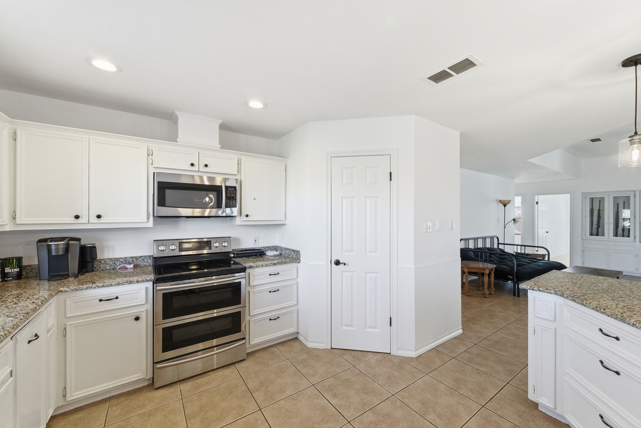 162 Farm To Market 672 Dale, TX 78616 - Photo 13 of 40 Kitchen featuring appliances with stainless steel finishes, light stone counters, white cabinets, light tile patterned flooring, and recessed lighting