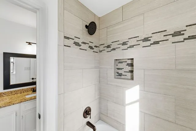 a bathroom with a granite countertop shower and a sink