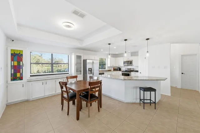 a kitchen with kitchen island a dining table and chairs