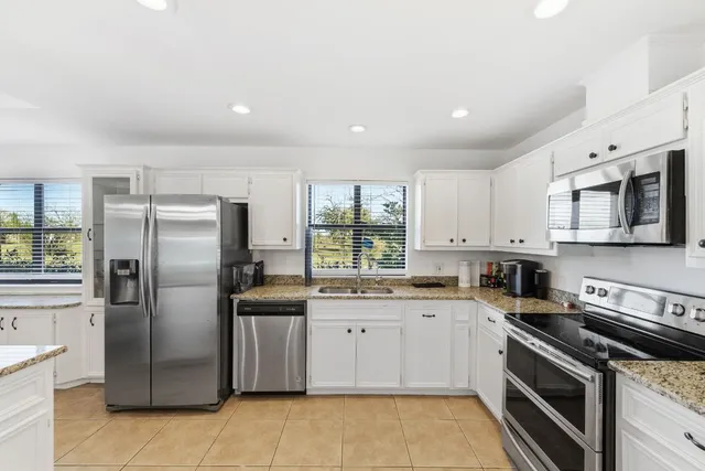 a kitchen with stainless steel appliances granite countertop a refrigerator sink and stove