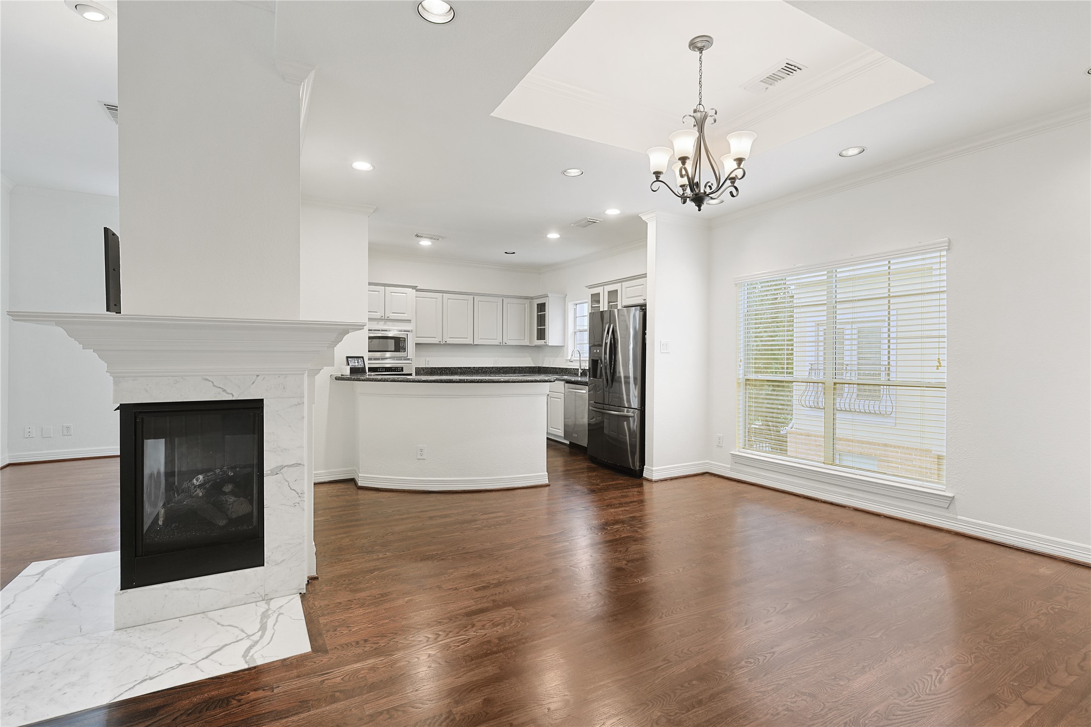 801 Knox Street Houston, TX 77007 - Photo 11 of 33 a view of a kitchen with a sink a kitchen island wooden floor and a fireplace