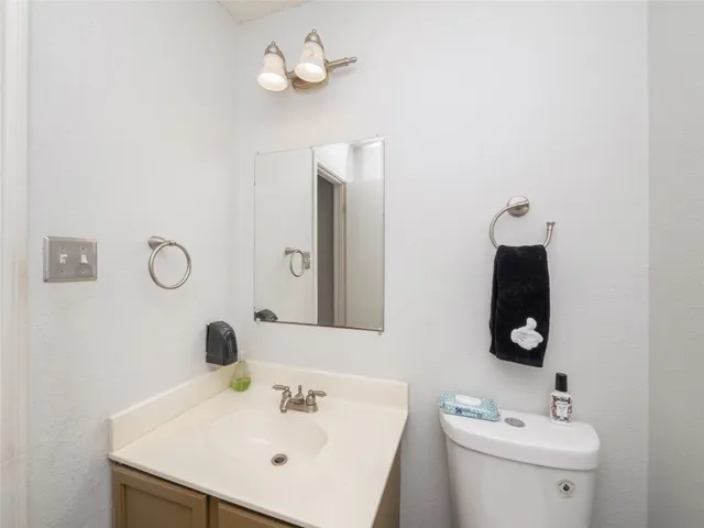 a bathroom with a sink vanity and toilet