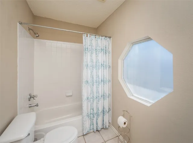 a bathroom with a shower a toilet and a bathtub