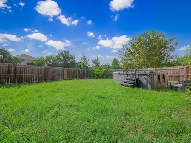 a view of a backyard with wooden fence
