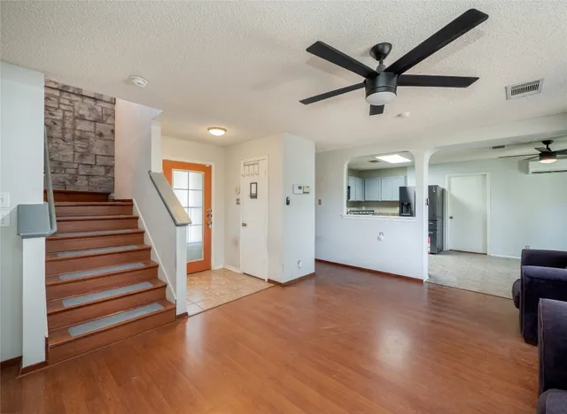 a view of a livingroom with wooden floor and stairs