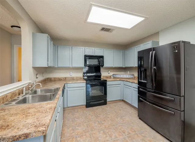 a kitchen with granite countertop stainless steel appliances and wooden cabinets