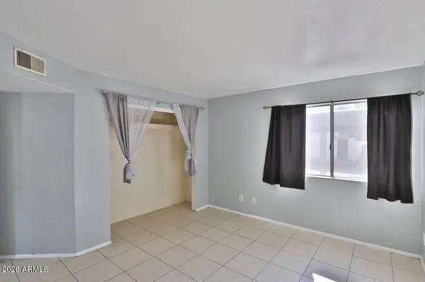 a view of an empty room with window and closet area