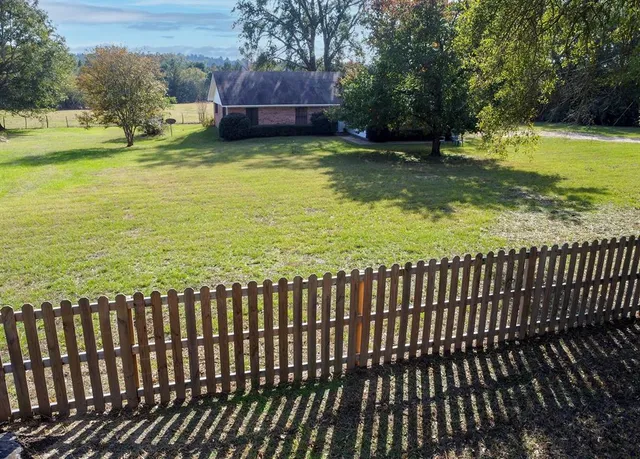 a view of a house with a yard and lake view