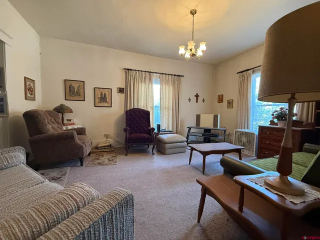 a living room with furniture a lamp and a chandelier